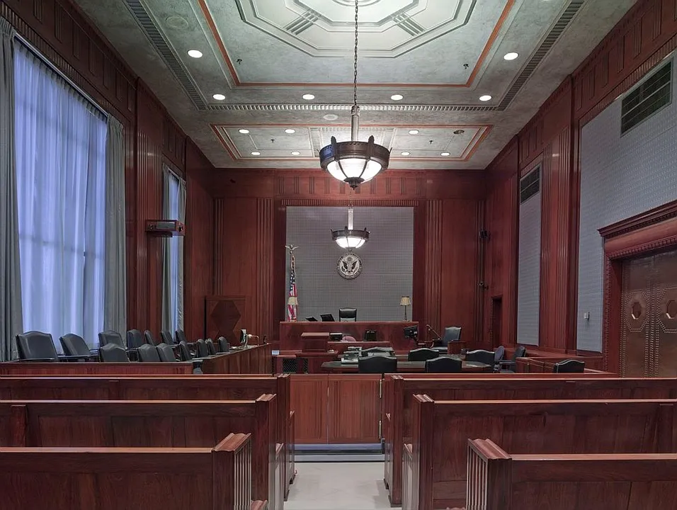 Sala de tribunal con estrado, bancos de madera y símbolos oficiales vinculada a traducciones legales y jurídicas