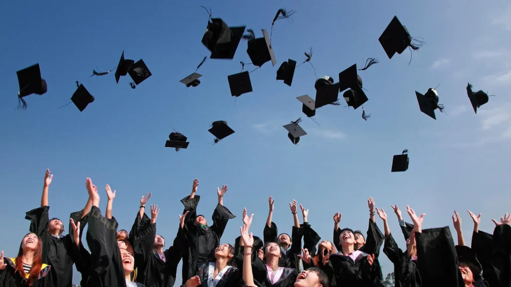Grupo de estudiantes celebrando su graduación universitaria, simbolizando el éxito académico y la finalización de sus trámites de traducción.